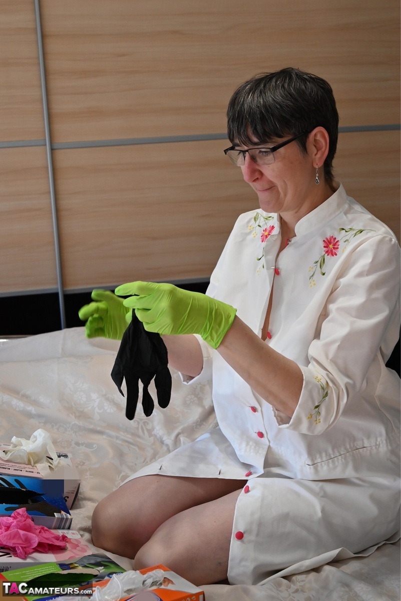 Amateur Woman Kneels On Her Bed While Donning Layers Of Latex Gloves