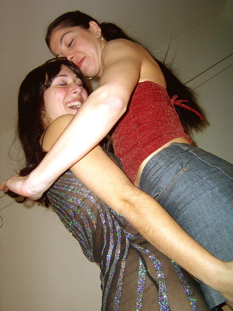 Brunette lesbians use a strapon cock while having sex on a sofa - NakedPics