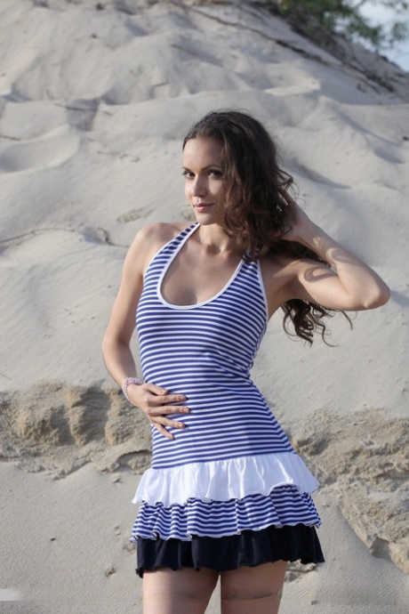 情色模特Kolumbina A在沙滩上光着脚展示漂亮的乳房和剃光的乳头