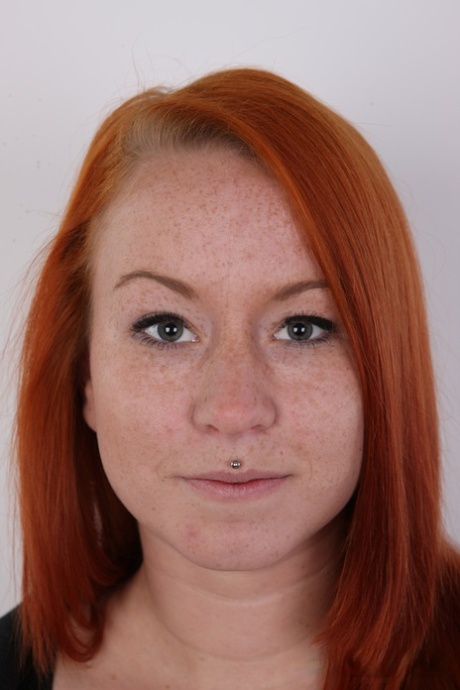 Freckled redhead Tereza shows her pierced pussy after getting completely naked