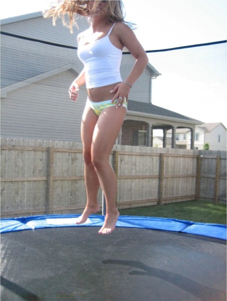 Ragazza amatoriale rimbalza su un trampolino in mutande e una camicia con spalline sottili