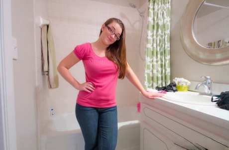 Schattige rondborstige Tiffany stript haar jeans en ondergoed om naakt in een warm bad te gaan