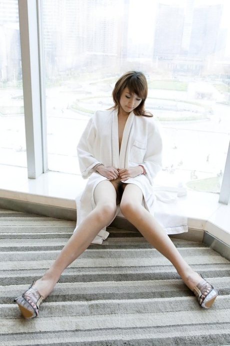 Petite Asian teen Lavinia Chan doffs a robe to pose naked on a window sill