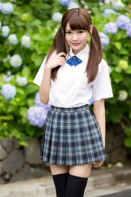Une jolie écolière japonaise avec des nattes montre son cul nu dans une jupe sans culotte.