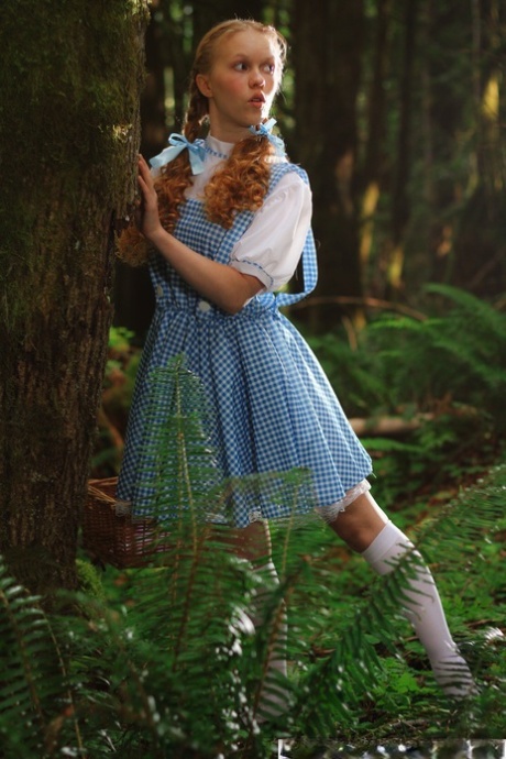 Charming redhead teen Dolly Little gets naked in white socks while in a forest
