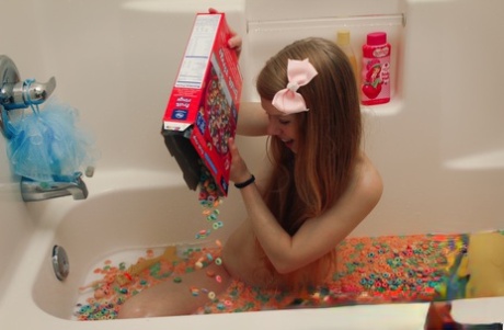 Молодая девушка Долли Литтл высыпает коробку хлопьев в воду для купания