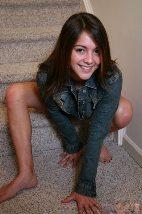 Une fille solo à peine légale exhibe ses seins dans un string rouge sur des marches d'escalier