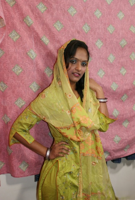 Indisk flicka tar av sig kläder och underkläder för nakenmodelldebut