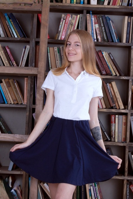 Thin teen girl shows off her cotton underwear while browsing books at library