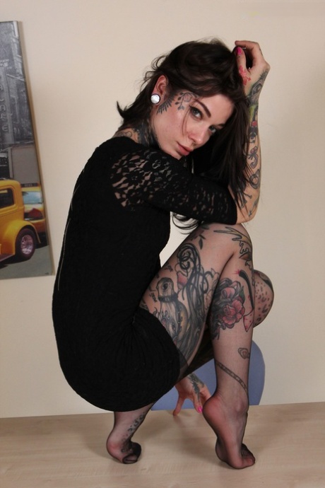 A secretária tatuada quente faz os seus óculos e modelos pernas sexy em meia-calça preta
