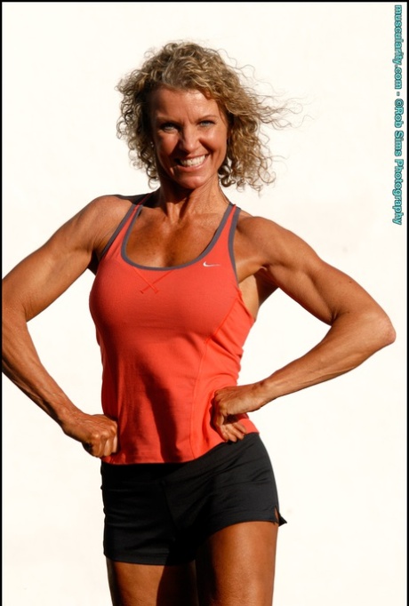 Bodybuilderen Denise James har krøllet hår, mens hun poserer udendørs i bikini