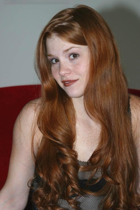 皮肤白皙的红发女郎蒂芙尼近距离展示她粉红色的少女阴部