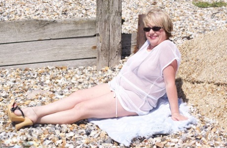 Overweight blonde Speedy Bee looses her tits and twat from a bikini at a beach