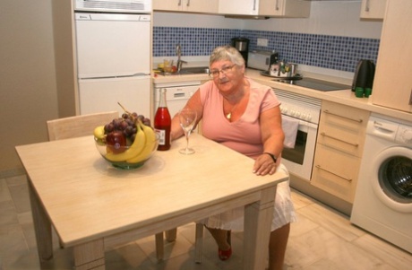 Dojrzała babcia BBW Libby rozbiera się w kuchni, aby napić się wina i zjeść obiad oraz zabawić się cipką nago
