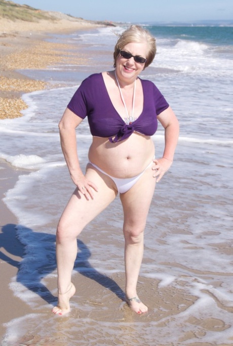 Mature amateur Speedy Bee gets naked in shades on a British beach
