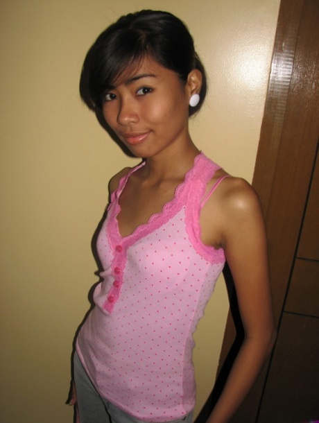 Schlankes 18-jähriges asiatisches Mädchen zeigt ihre haarlose Muschi nach einem Striptease
