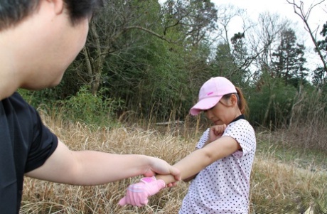 Japanska Nao Yuzumiya suger sperma från en kuk på sina knän outdors