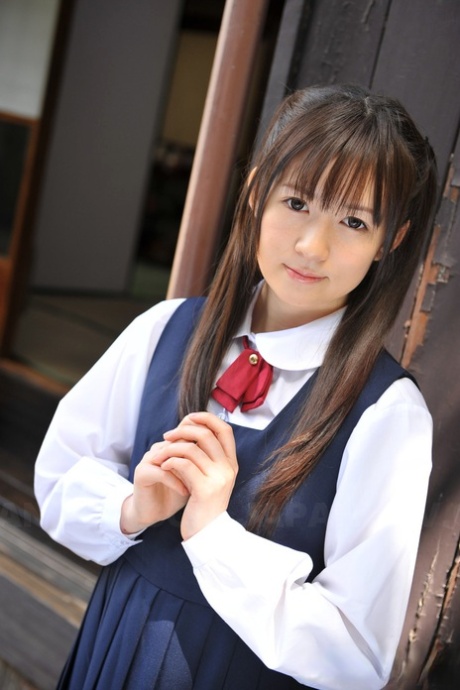 Encantadora japonesa posando em seu lindo traje escolar no jardim