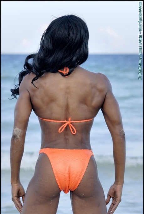 Эбеновая культуристка Дебра Данн позирует на берегу океана в бикини-стрингах