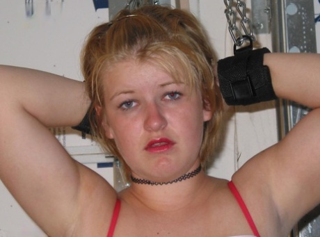 Chubby blonde is fitted with a ball gag before having her breasts exposed