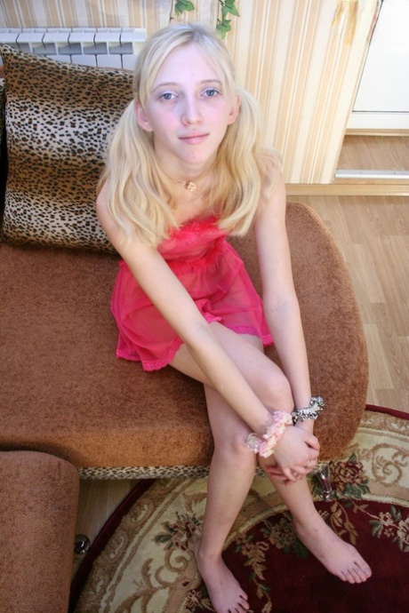 Ung blond tjej visar sina bröst och sin fitta i rena underkläder och flätor