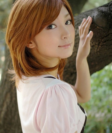 Jovem japonesa de cabelo ruivo mostra a sua roupa interior de camisa de cima