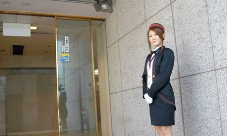 Une hôtesse japonaise aux cheveux roux caresse son grand corps dans une chambre d