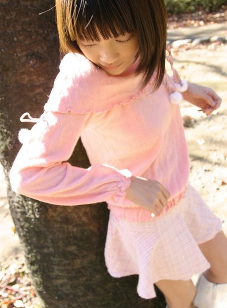 La jolie Japonaise Nana exhibe ses seins fermes et sa culotte en coton dans le jardin.