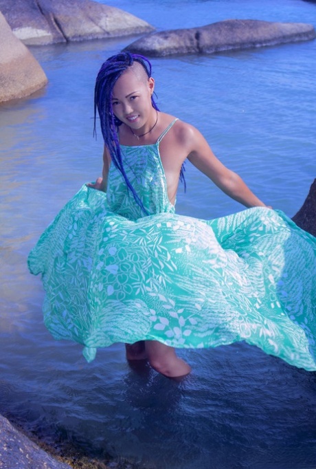 Gorąca azjatycka nastolatka Sweet Julie zdejmuje mokrą sukienkę i pozuje nago w wodzie
