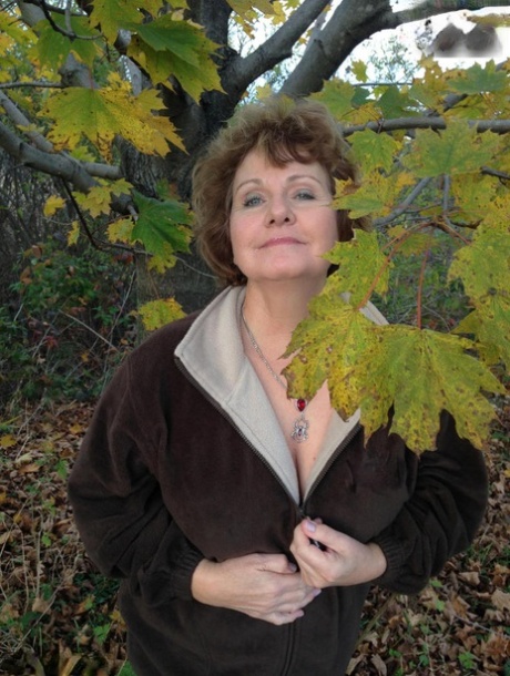 Eldre Kvinne Busty Bliss utsetter hennes store naturlige pupper under et tre i høst