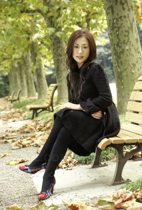 Fullklädda japanska tonårsmodeller i parken i svarta kläder och strumpor