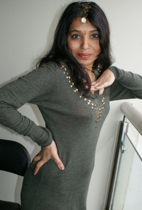 A senhora indiana Kavya Sharma senta-se numa almofada depois de tirar a roupa e as botas