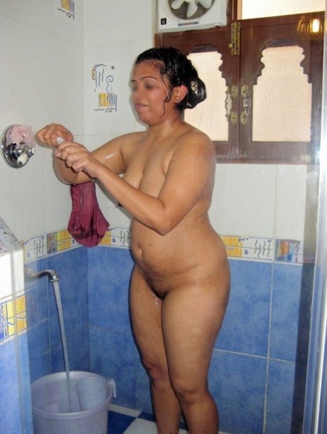 Amante indiana paffuta si lava i capelli e si depila le ascelle sotto la doccia