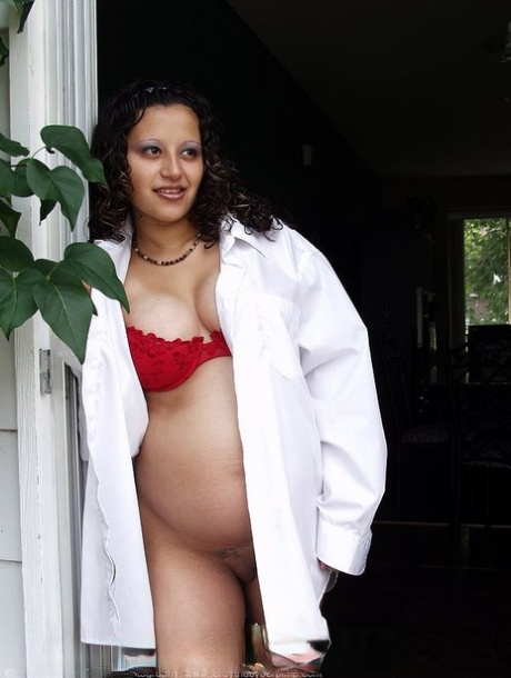 Těhotná Latinoameričanka ukazuje svá mlékem naplněná prsa a bříško nahá