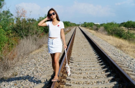 Baby Shine, uma adolescente magra, fica nua de chinelos nos carris dos caminhos-de-ferro