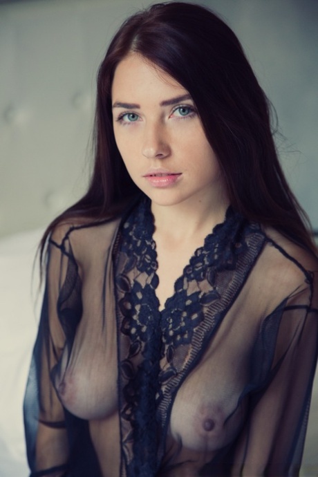 Gorgeous brunette Niemira removes sheer lingerie to stand naked on a bed
