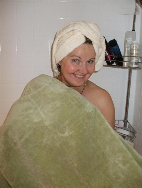 Naakte oudere vrouw Busty Bliss wast haar grote borsten tijdens het douchen