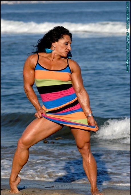 Brunette Bodybuilder Tonia Moore Flexes Her Muscles On A Beach In A Dress Nakedpics