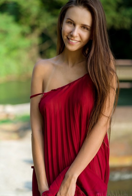 Mooie tiener Alisa Amore kleedt zich uit voor naakt solo poses bij een dam