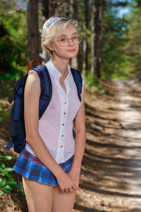 Junges Mädchen Azshara zieht die Schulkleidung auf einem Feldweg im Wald aus