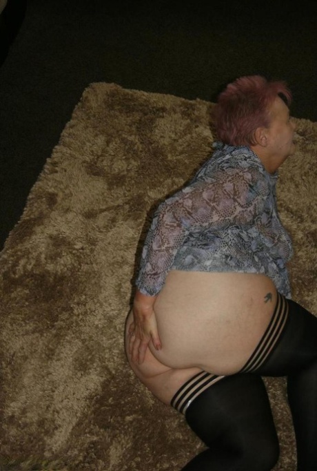 Fat nan Valgasmic Exposed kaster av seg kjolen for å gå naken i svarte strømper.
