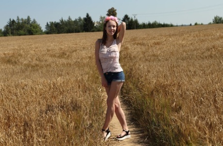 Śliczna nastolatka Nata wbija ogórka w swoją nagą cipkę na polu rolnika