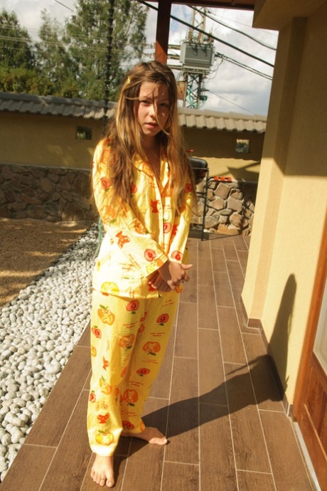 Adolescente encantadora suelta sus pequeñas tetas y culo del pijama en chanclas