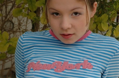 Молодая девушка снимает прозрачные трусики, раздеваясь на террасе в саду