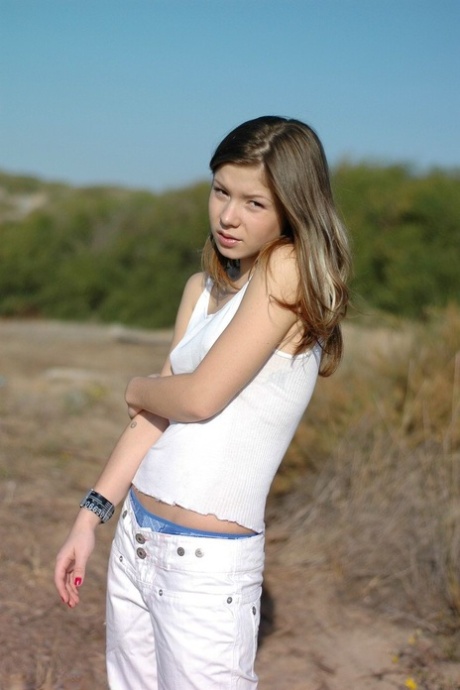 Charmantes junges Mädchen zeigt ihre Unterwäsche, nachdem sie ihre kleinen Titten entblößt hat