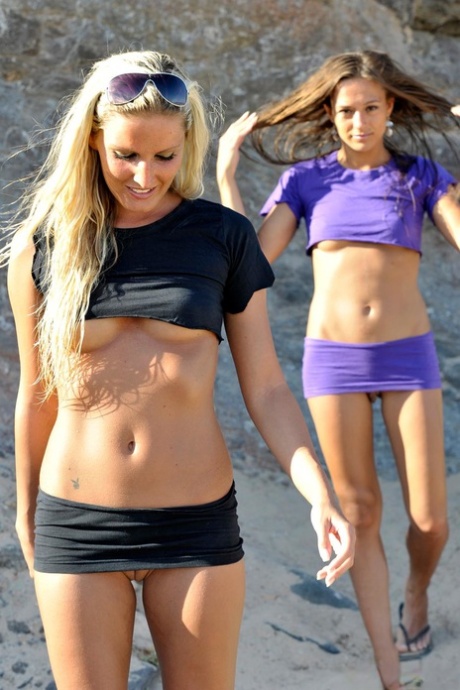 Две девушки обнажают свои сиськи и бритые киски на песчаном пляже
