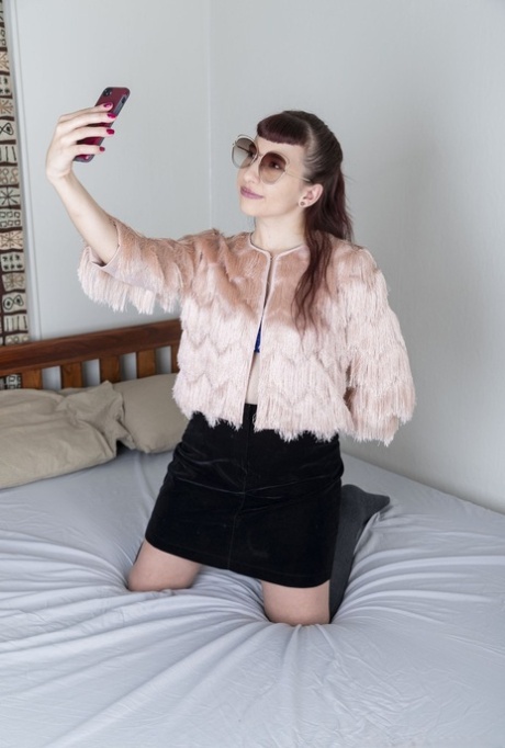 Owłosiona amatorka Calliope robi sobie selfie podczas rozbierania się na łóżku