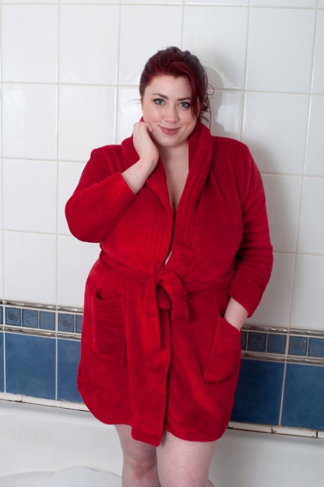 Fed rødhåret kvinde med store bryster og en stor røv skåler under et bad
