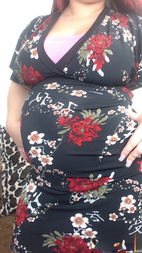 Die schwangere Rothaarige Georgia Peach zieht ihr Kleid aus und posiert nackt auf dem Sofa