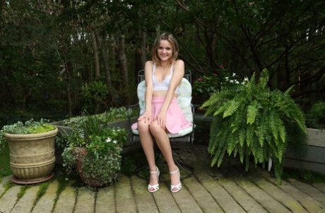 Addee Kate, une adolescente, se fait plaisir sur une chaise, sur une terrasse en bois.